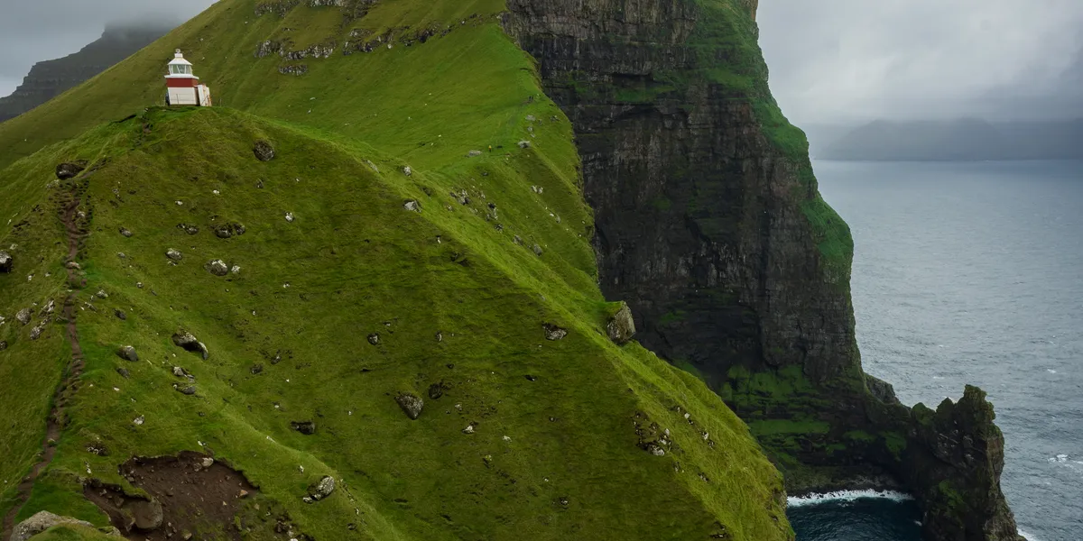 The iconic view of the lighthouse with the cliff in the background.