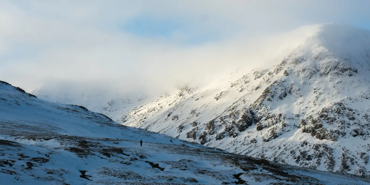 A lone hiker on the snowy slopes