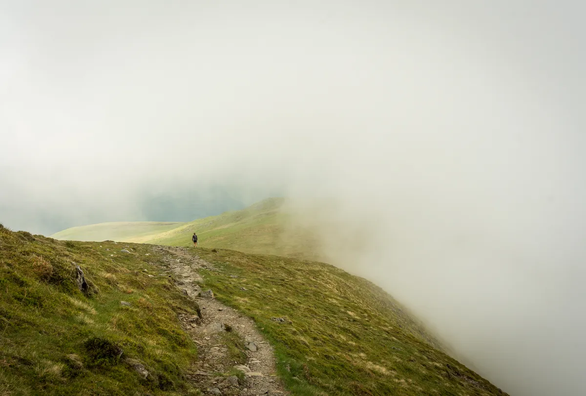 Cloud engulfing a lone hiker